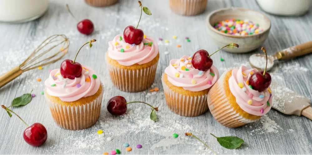 Frisch gebackene Cupcakes mit rosa Zuckerguss und Kirschen verfeinert mit Premium Dessert Gewürzen online kaufen bei chefkoch-gewürze Schweiz